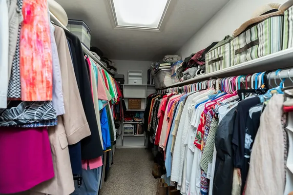 a view of walk in closet with clothes and shoes