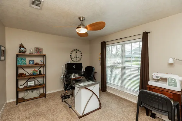 a view of a workspace with furniture and a window