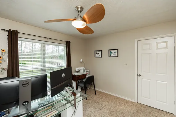 a view of a workspace with furniture and a window