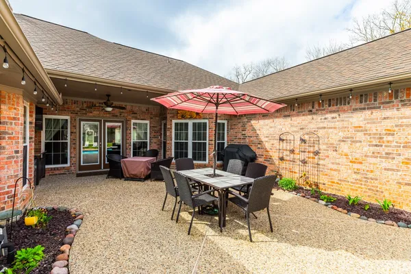 a view of a patio with a table and chairs under an umbrella