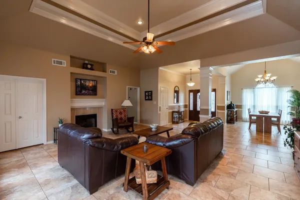 a living room with furniture a fireplace and a chandelier