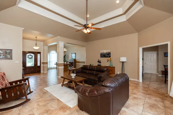 a living room with furniture a ceiling fan and a rug