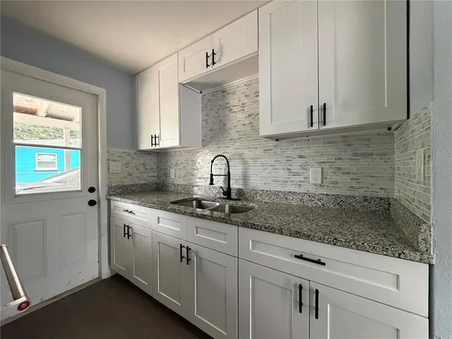 a kitchen with stainless steel appliances white cabinets and a sink