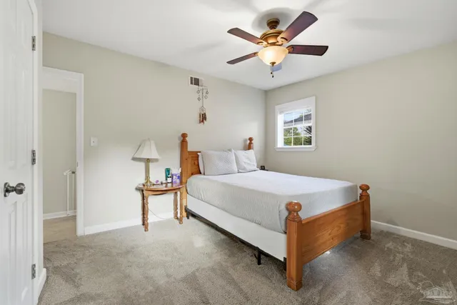 a bed room with a bed and a ceiling fan