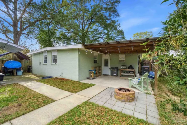a backyard of a house with barbeque oven table and chairs