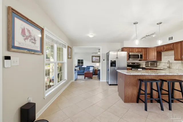 a kitchen with stainless steel appliances granite countertop a refrigerator and a stove top oven