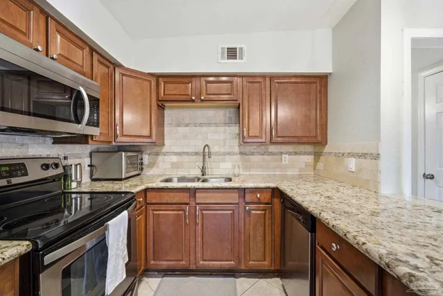 a kitchen with stainless steel appliances granite countertop a sink stove microwave and cabinets