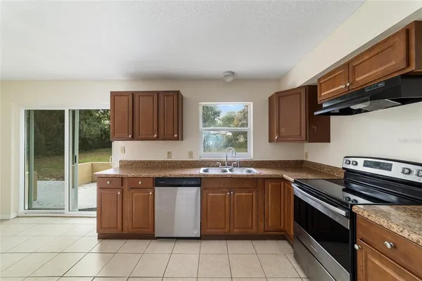 a kitchen with stainless steel appliances granite countertop a stove a sink and a microwave