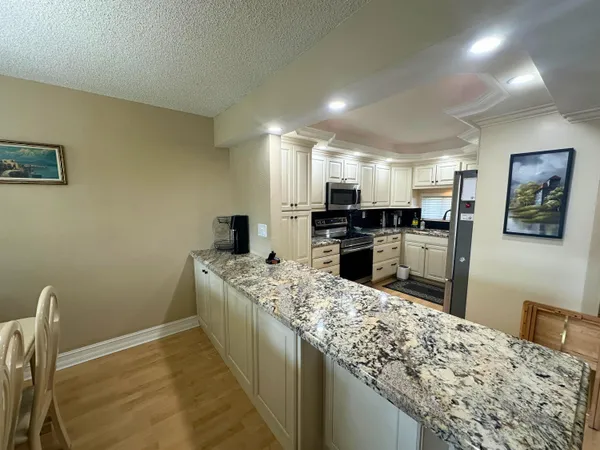 a kitchen with stainless steel appliances granite countertop a sink stove and refrigerator