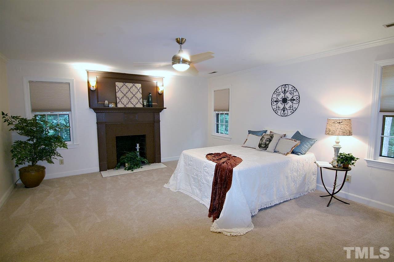 2001 Countrywood Road North Raleigh, NC 27615 - Photo 11 of 25 a spacious bedroom with a bed and a fireplace