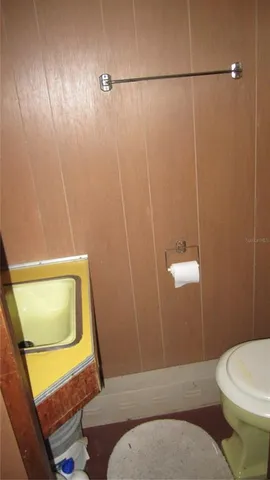 a bathroom with a toilet and a mirror