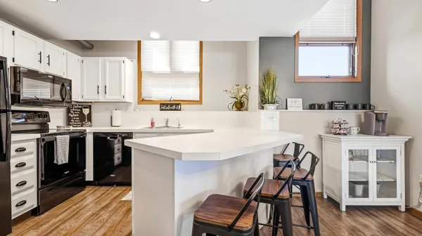 a kitchen with a table chairs a oven a sink dishwasher and cabinets with wooden floor