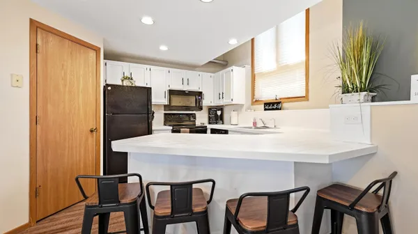 a kitchen with stainless steel appliances a table chairs and a refrigerator