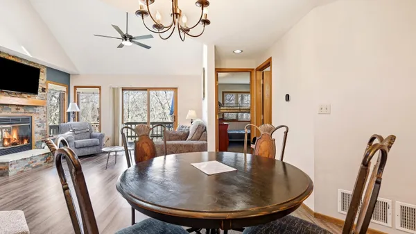 a dining room with furniture a chandelier and wooden floor