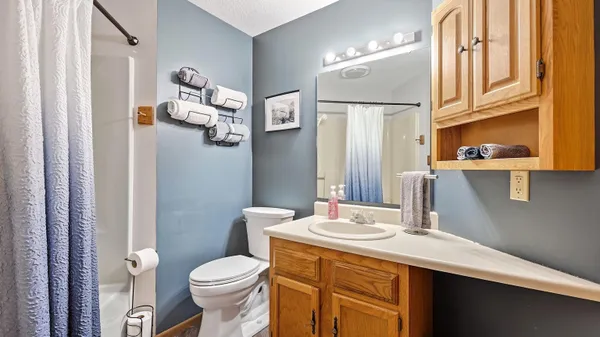 a bathroom with a sink a toilet and shower curtain