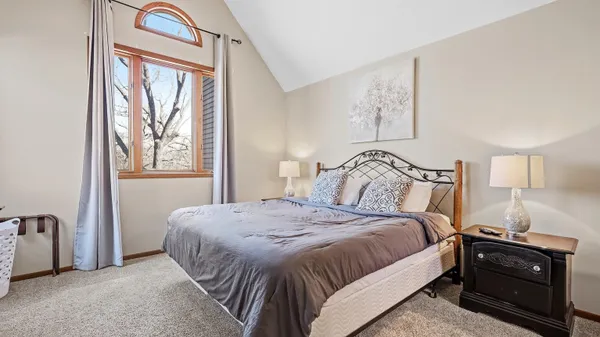 a bedroom with a bed and a lamp on dresser