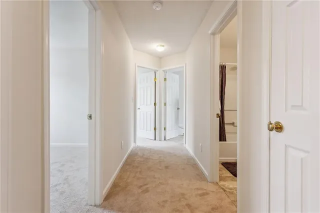 a view of a hallway with wooden floor and closet
