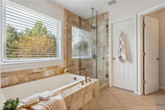 a spacious bathroom with a tub shower and windows