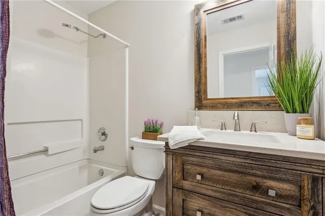 a bathroom with a sink vanity mirror and toilet