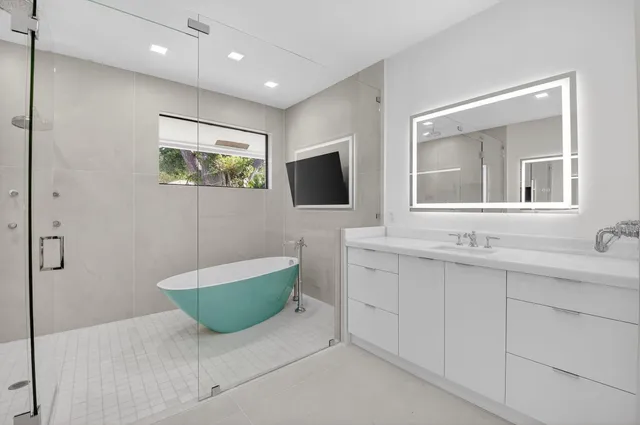 an aerial view of a city with lots of residential buildings ocean and mountain view in back