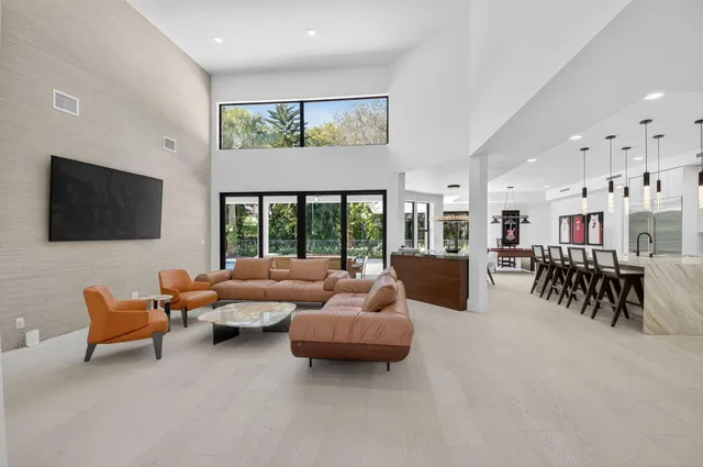 a large kitchen with stainless steel appliances kitchen island granite countertop a table chairs and a refrigerator