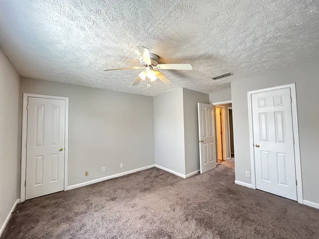 an empty room with fan and entrance