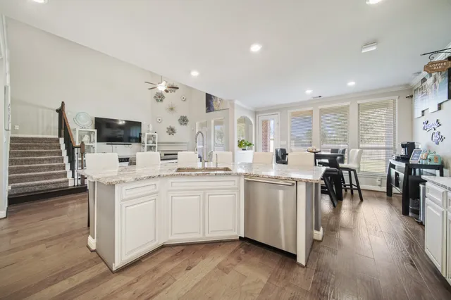 a large white kitchen with lots of counter space a sink appliances and a large window