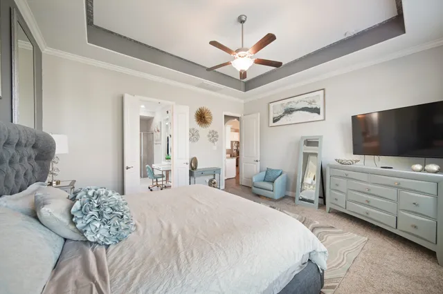 a bedroom with a bed a flat screen tv and a chandelier