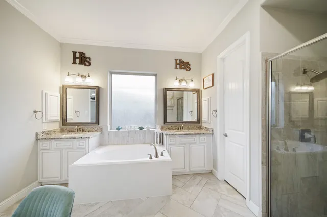 a spacious bathroom with a tub sink and mirror