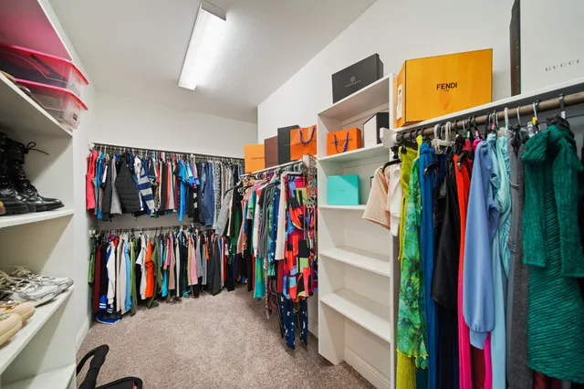 a view of walk in closet with clothes
