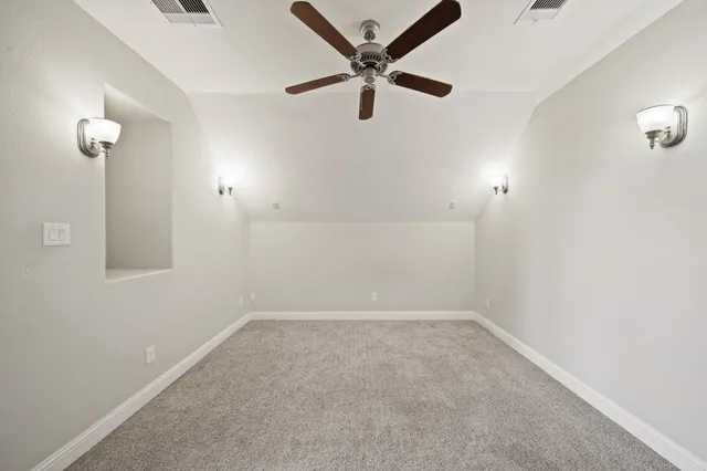 an empty room with a window and a ceiling fan