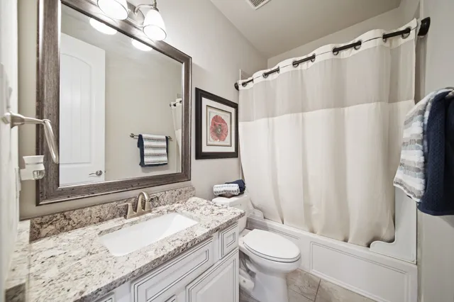 a bathroom with a granite countertop sink toilet and shower