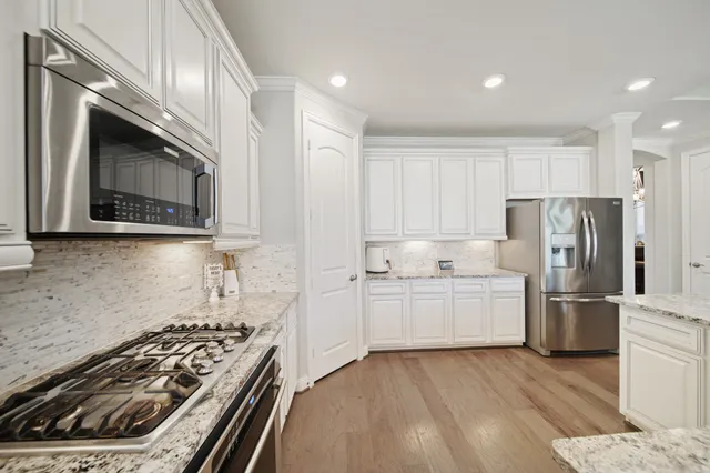 a kitchen with white cabinets and stainless steel appliances