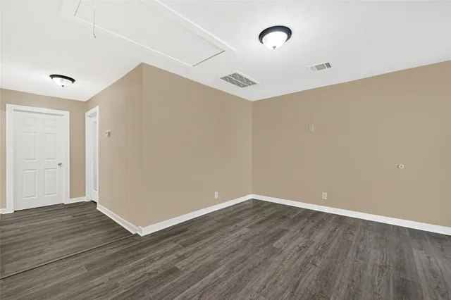 a view of an empty room with wooden floor