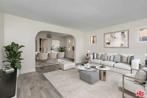 a living room with furniture and view of kitchen