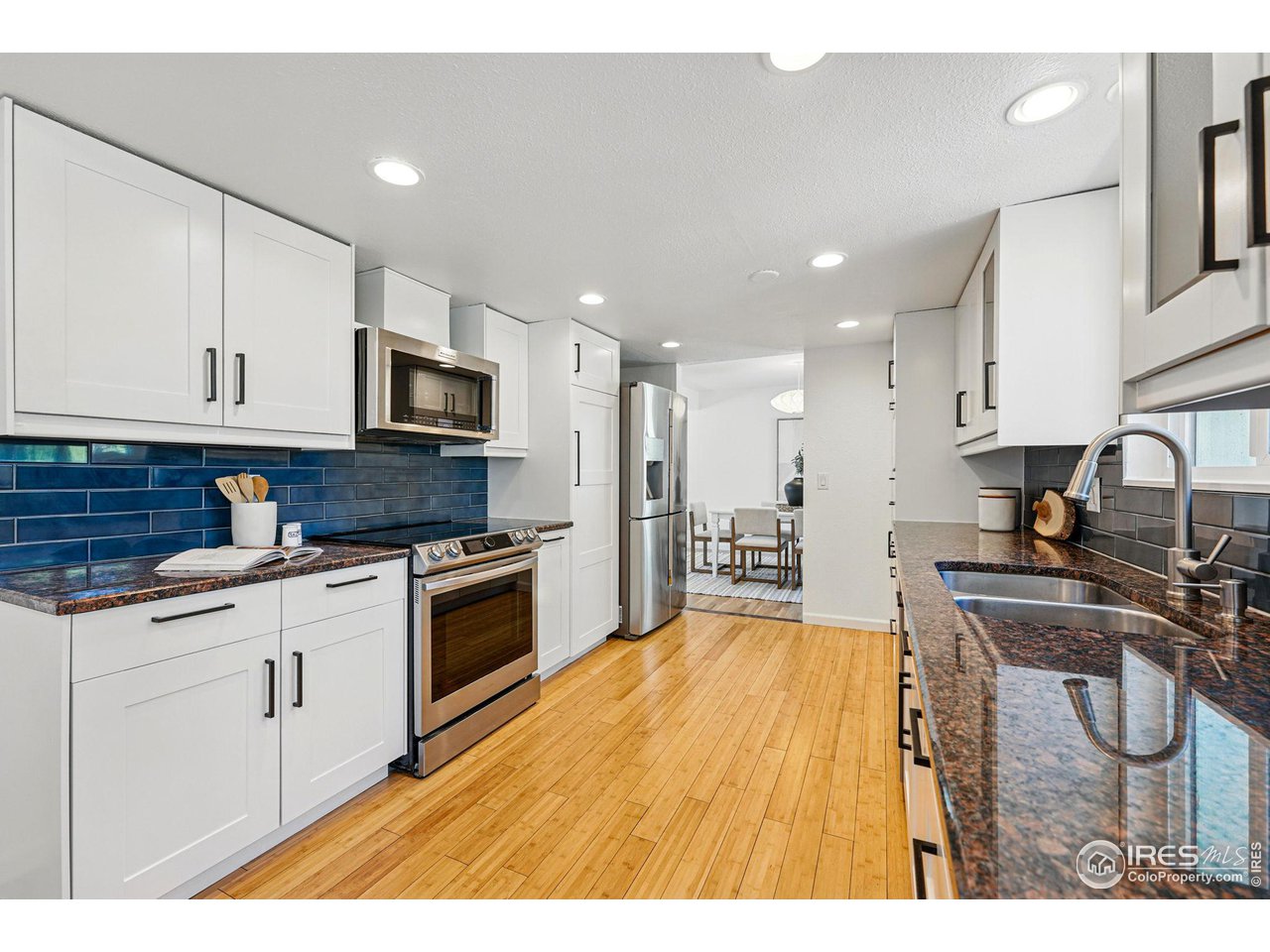 3495 Endicott Drive Boulder, CO 80305 - Photo 11 of 40 a kitchen with stainless steel appliances granite countertop a stove top oven a sink a refrigerator and white cabinets
