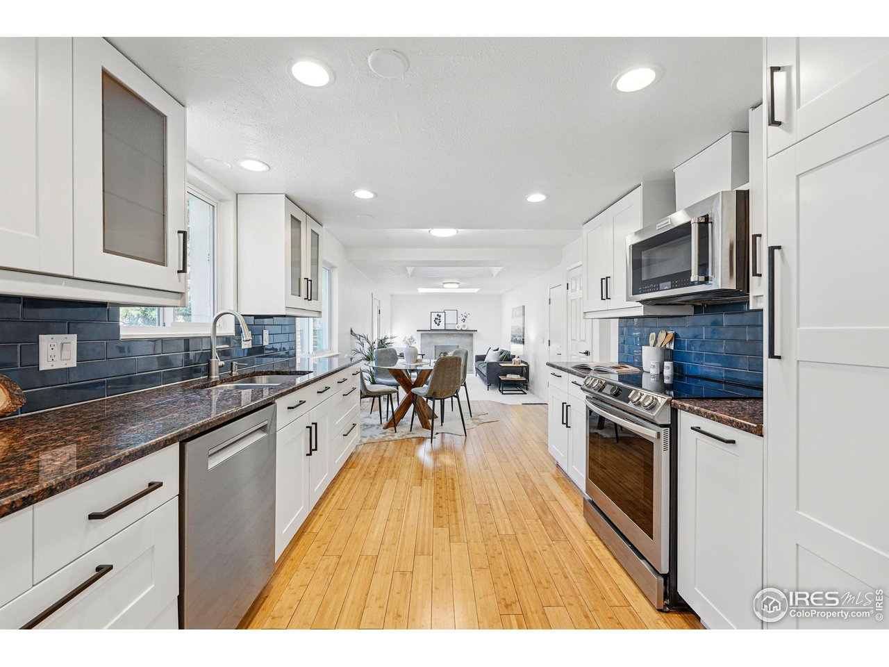 3495 Endicott Drive Boulder, CO 80305 - Photo 8 of 40 a kitchen with stainless steel appliances granite countertop a refrigerator a stove top oven a sink dishwasher and white cabinets with wooden floor