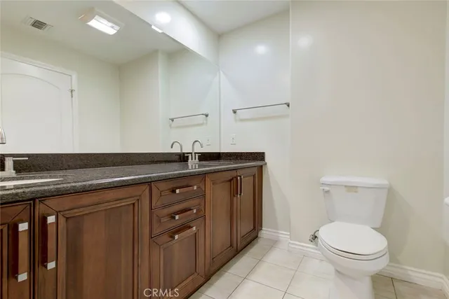 a view of a hallway with wooden floor and a bathroom