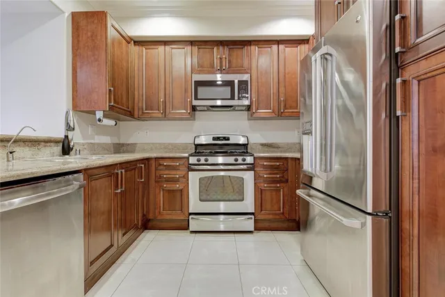 a kitchen with granite countertop a refrigerator stove and microwave