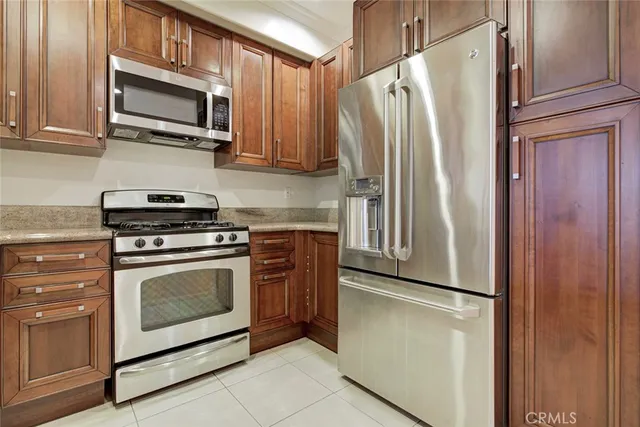 a kitchen with granite countertop a refrigerator stove and microwave