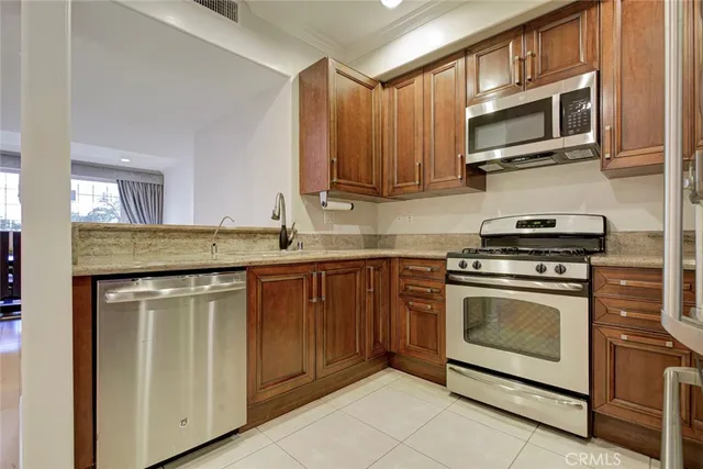 a kitchen with stainless steel appliances granite countertop a stove microwave and cabinets