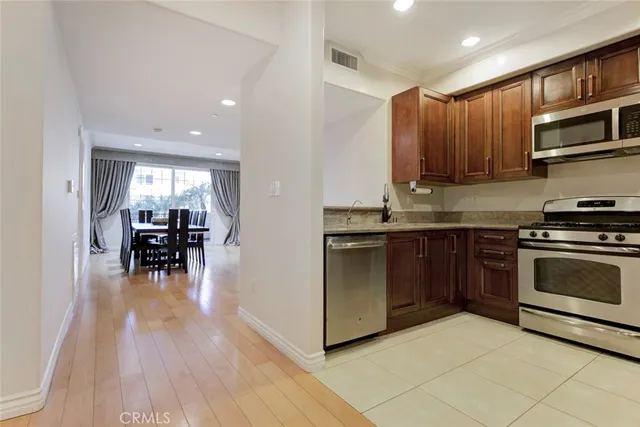 a kitchen with stainless steel appliances granite countertop a stove and a wooden floors