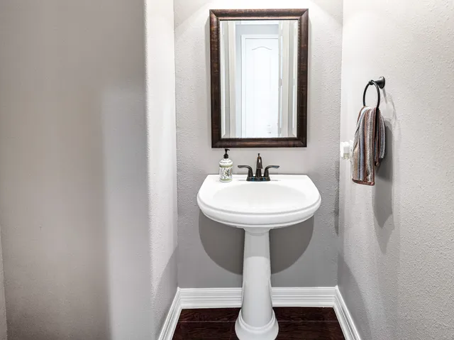 a bathroom with a granite countertop sink and a mirror with toilet
