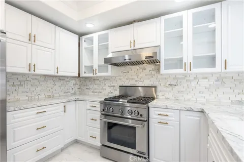 a kitchen with granite countertop white cabinets and white appliances