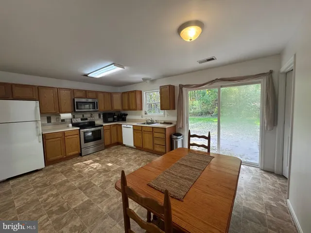 a kitchen with a sink a stove and chairs