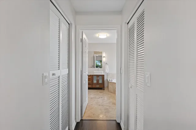 a view of a hallway with a livingroom and a bathroom with sink