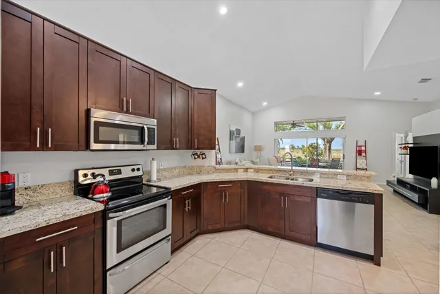 a kitchen with stainless steel appliances granite countertop wooden cabinets a sink and dishwasher