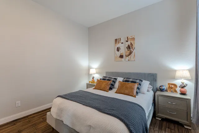 a bedroom with a bed and wooden floor