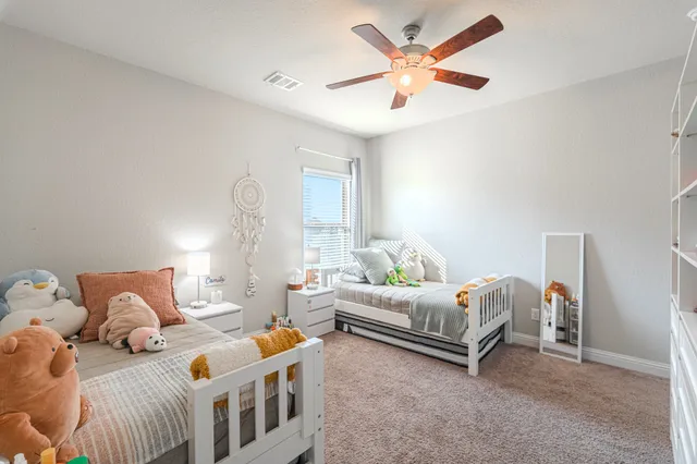 a bedroom with two beds and a chandelier