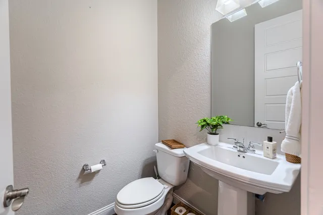 a bathroom with a sink a toilet and mirror